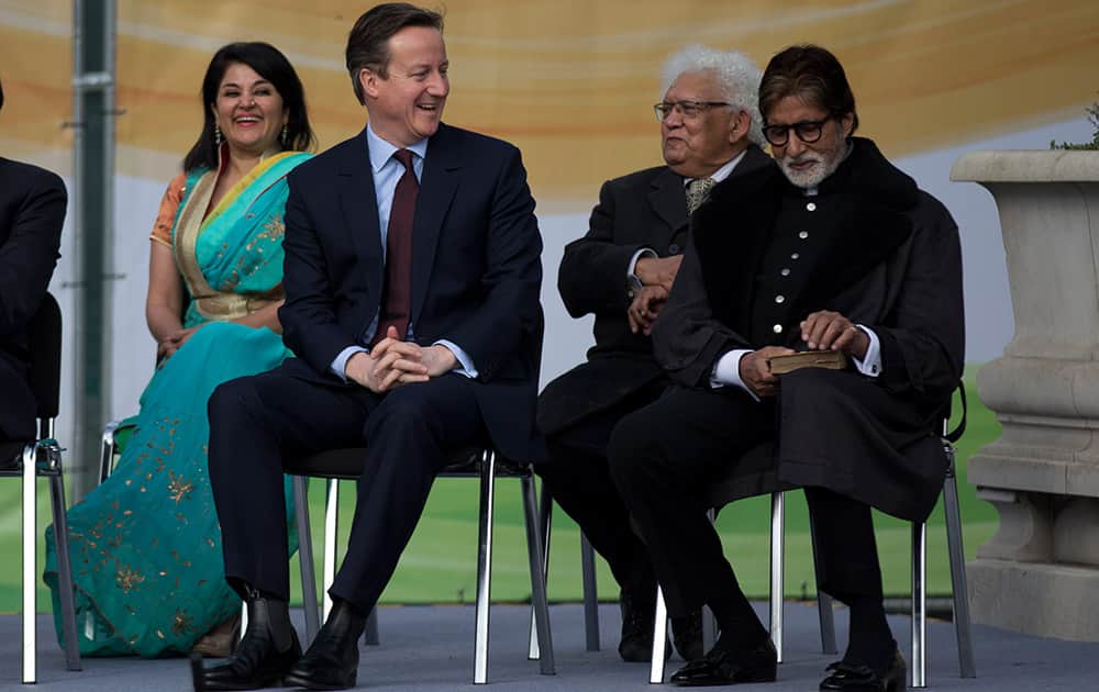 British Prime Minister David Cameron sits on the stage next to Bollywood actor Amitabh Bachchan during the unveiling ceremony for a new statue of Mahatma Gandhi by British sculptor Philip Jackson in Parliament Square, London.