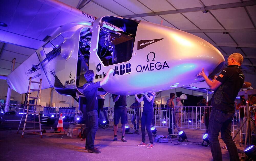 Crew members remove the cockpit cover of Solar Impulse 2 for maintenance work in Ahmedabad.