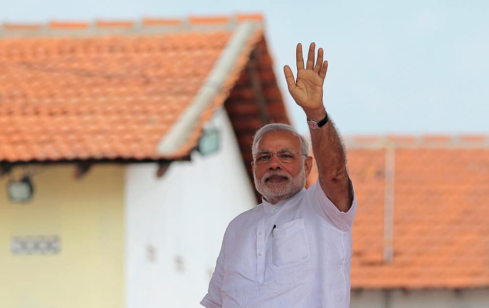 Prime Minister Narendra Modi waves to the gathering during the handing over of homes under a housing scheme funded by the Indian government for war victims in Llavalai, northwest of Jaffna, Sri Lanka.