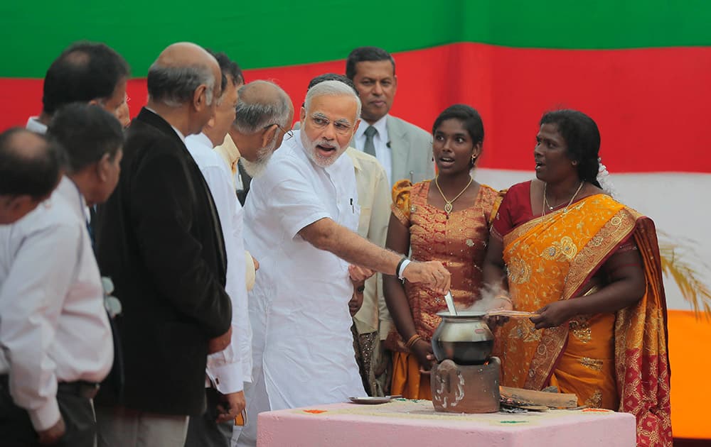 Prime Minister Narendra Modi stirs a pot of milk, a customary ritual that marks an opening, during the handing over of homes under a housing scheme funded by the Indian government for war victims in Llavalai, northwest of Jaffna, Sri Lanka.