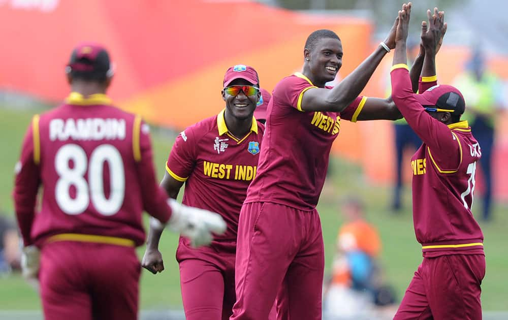 West Indies bowler Jason Holder, second left, is congratulated by teammates after bowling United Arab Emirates batsman Swapnil Patil during their Cricket World Cup Pool B match in Napier, New Zealand.