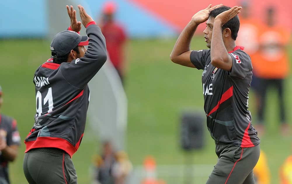 United Arab Emirates bowler Amjad Javed, right, is congratulated by his teammate Andri Raffaelo after taking the wicket of West Indies batsman Andre Russell during their Cricket World Cup Pool B match in Napier, New Zealand.