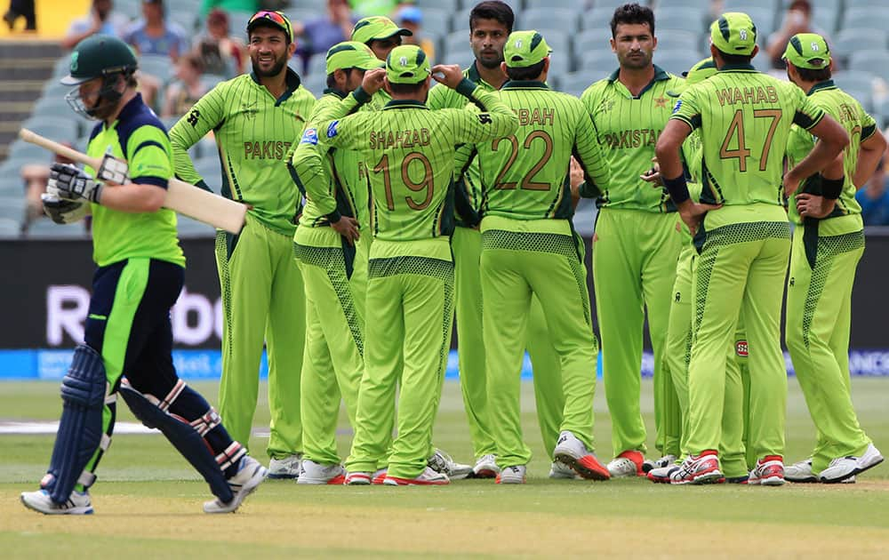 Ireland's Paul Stirling walks back after his dismissal as Pakistan players celebrate during their Cricket World Cup Pool B match in Adelaide, Australia.