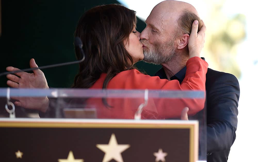 Marcia Gay Harden, left, kisses Ed Harris as he is honored with a star on the Hollywood Walk Of Fame in Los Angeles. 