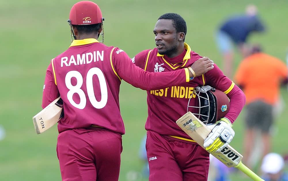 West Indies batsman Denesh Ramdin, left, celebrates with teammate Jonathan Carter after they won their Cricket World Cup Pool B match by six wickets against the United Arab Emirates in Napier, New Zealand.