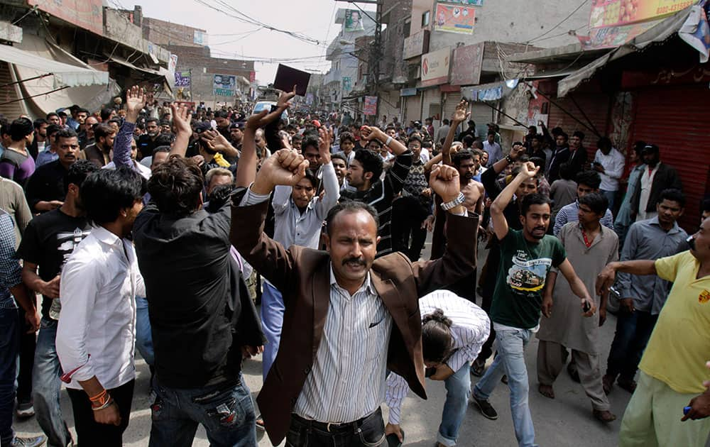 Pakistani Christians chant slogans near the site of suicide bombing attack on two churches in Lahore, Pakistan.