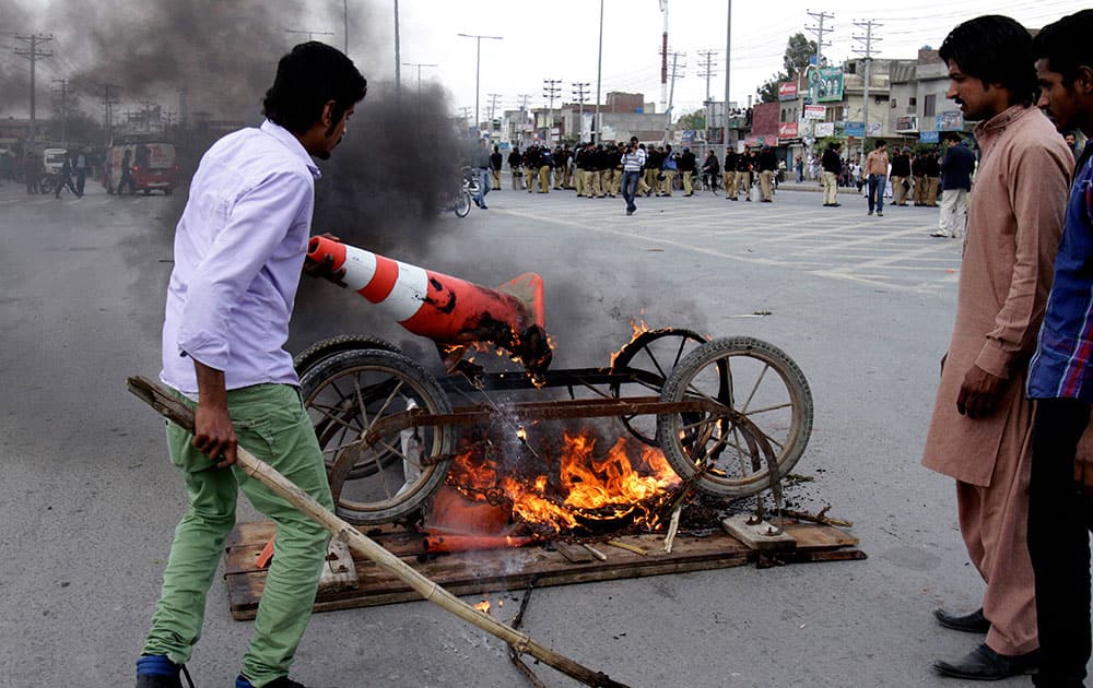 Pakistani Christians burn a cart at a road to protest against the suicide bombing attack on two churches in Lahore, Pakistan.