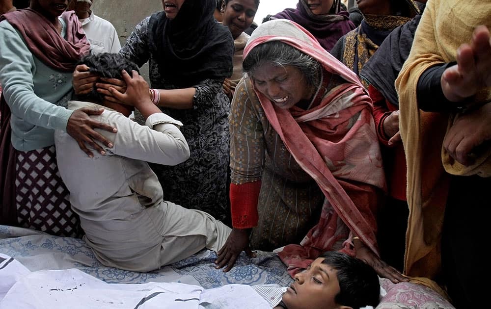 A Pakistani Christian family mourn next to the lifeless body of a boy who was killed from a suicide bombing attack near two churches in Lahore, Pakistan.