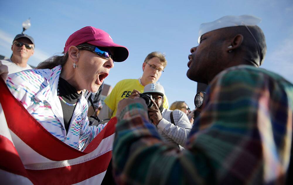 A pro-police protester, left, and counter protester yell at each other outside the Ferguson Police Department, in Ferguson, Mo.