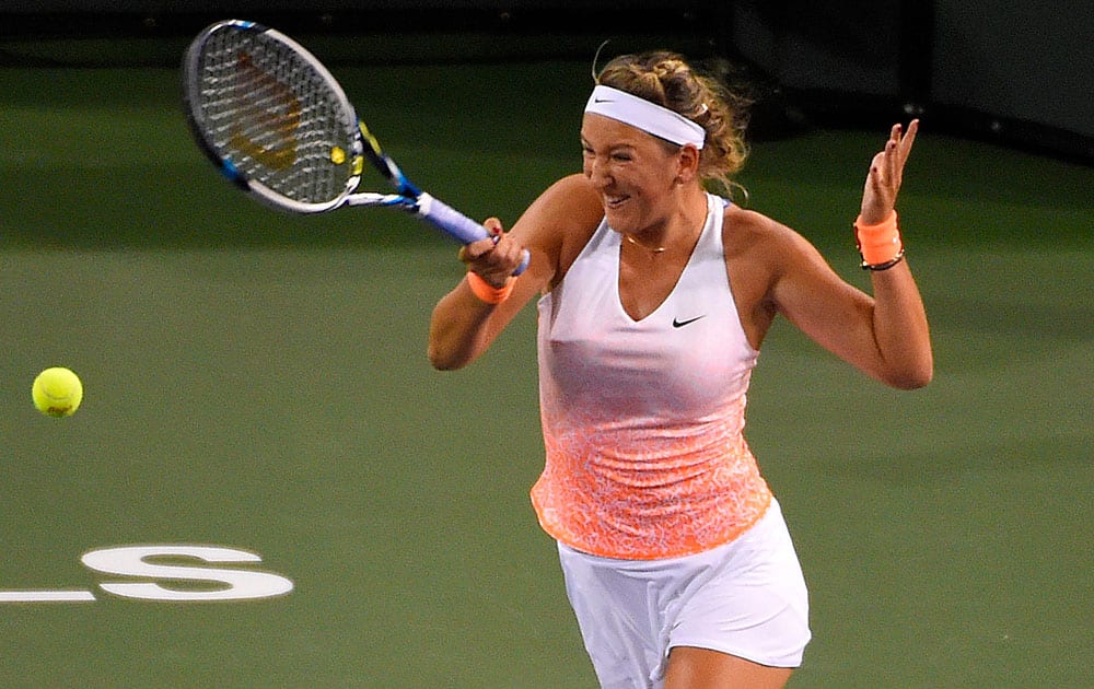 Victoria Azarenka, of Belarus, returns a volley from Maria Sharapova, of Russia, during their match at the BNP Paribas Open tennis tournament.