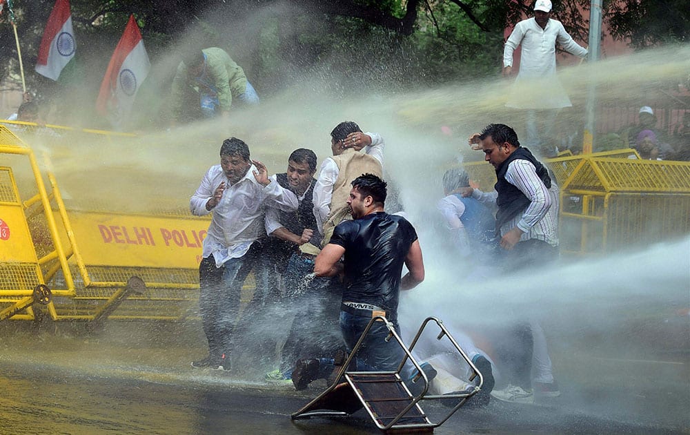 police use water cannons to disperse activists of opposition Congress party’s youth wing after they jumped police barricades during a protest against the government’s land acquisition bill, in New Delhi.