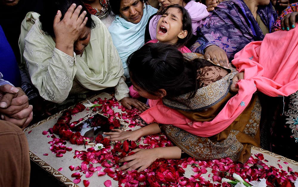 Family members of Pakistani Christian community mourn the death of a victim of Sunday's suicide bombings that struck two churches, in Lahore, Pakistan.