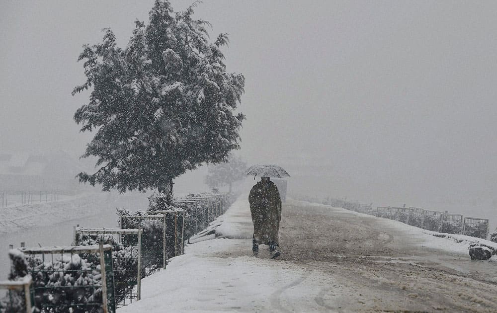 A man walks with umberalla during heavy snowfall in Srinagar. 