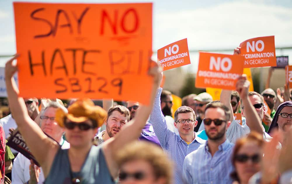 Protestors hold up signs during a rally against a contentious 