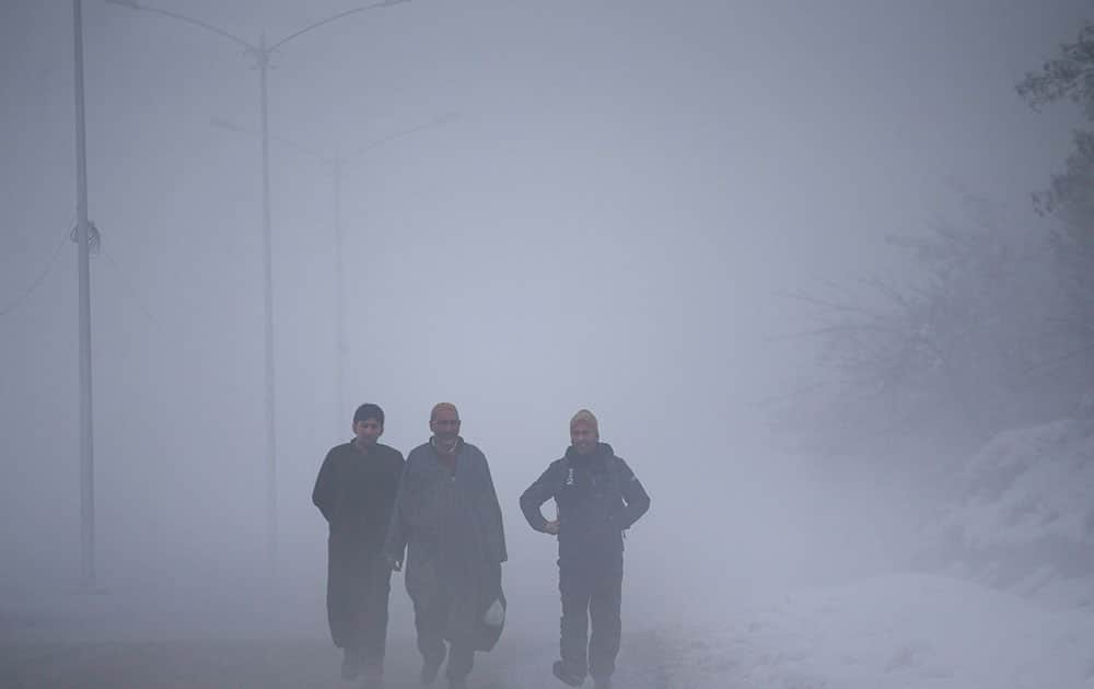 Kashmiri villagers walk on a road engulfed in fog in Tangmarg, about 38 kilometers (24 miles) northwest of Srinagar, India.