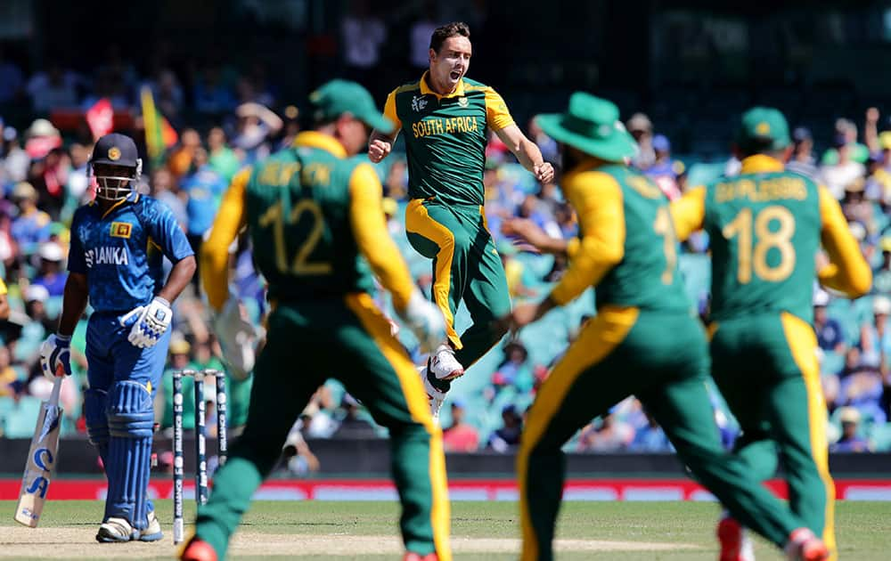 South Africa's Kyle Abbott leaps in the air as he celebrates the dismissal of Sri Lanka's Kusal Perera, left, during their Cricket World Cup quarterfinal match in Sydney, Australia.