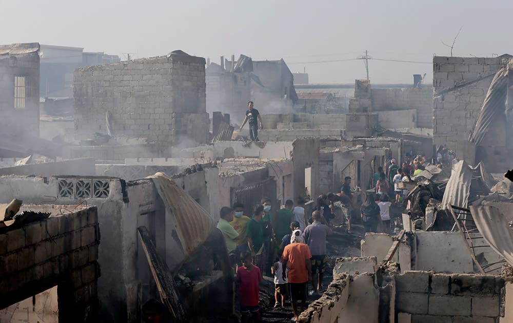 Residents sift through the debris following an overnight fire that gutted an informal settlers' community at Malabon city, north of Manila, Philippines.