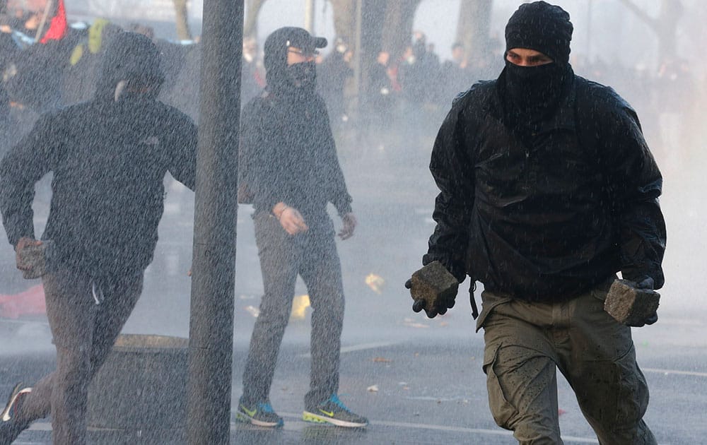 A protestor holds stones as water cannons of the police approach in Frankfurt, Germany. The Blockupy alliance said activists plan to try to blockade the new headquarters of the ECB to protest against government austerity and capitalism.