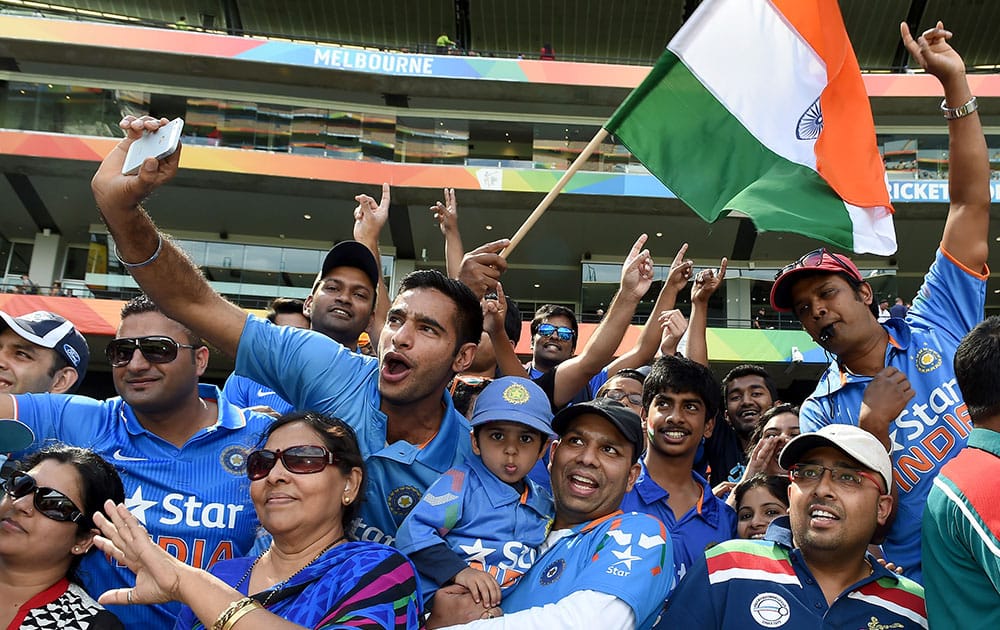 Indian fans wave flags and cheer their team during their Cricket World Cup quarterfinal match against Bangladesh in Melbourne, Australia.