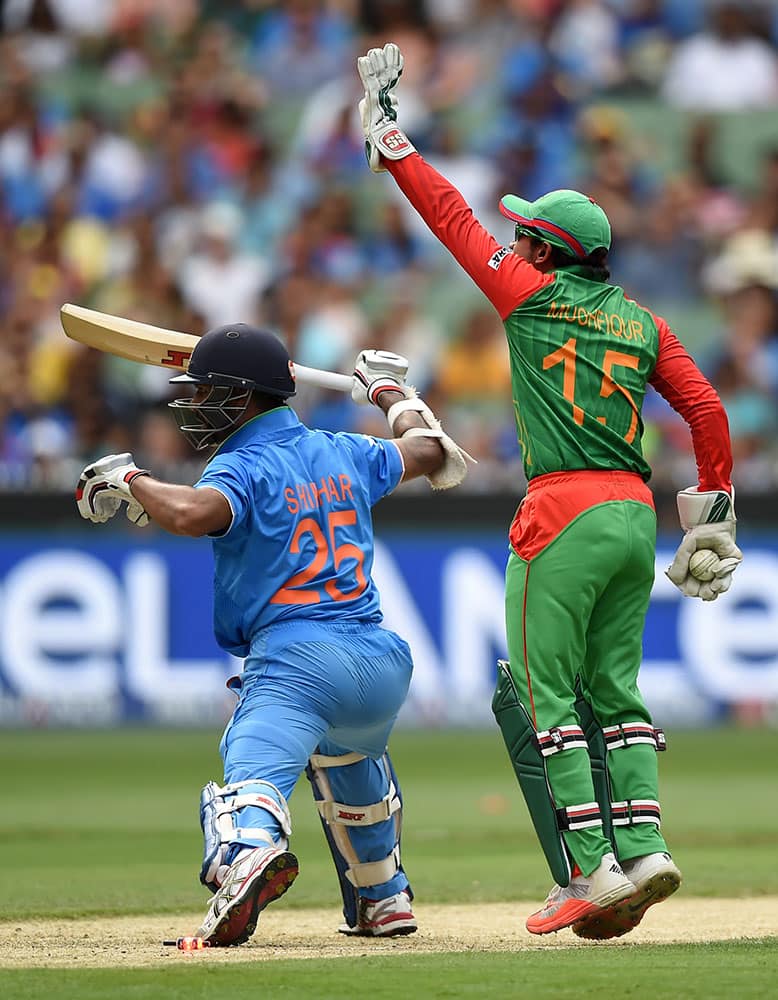 Bangladesh’s Mushfiqur Rahim appeals successfully for the stumping of India's Shikhar Dhawan, left, during their Cricket World Cup quarterfinal match in Melbourne, Australia.