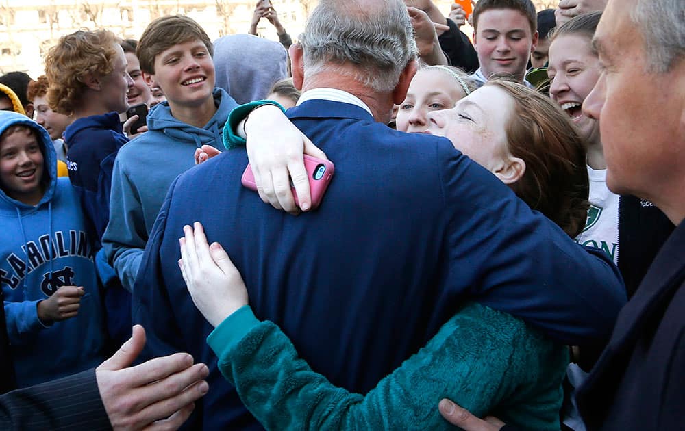 Schoolgirls ask for and receive a hug from Britain's Prince Charles after his visit to the National Archives in Washington.