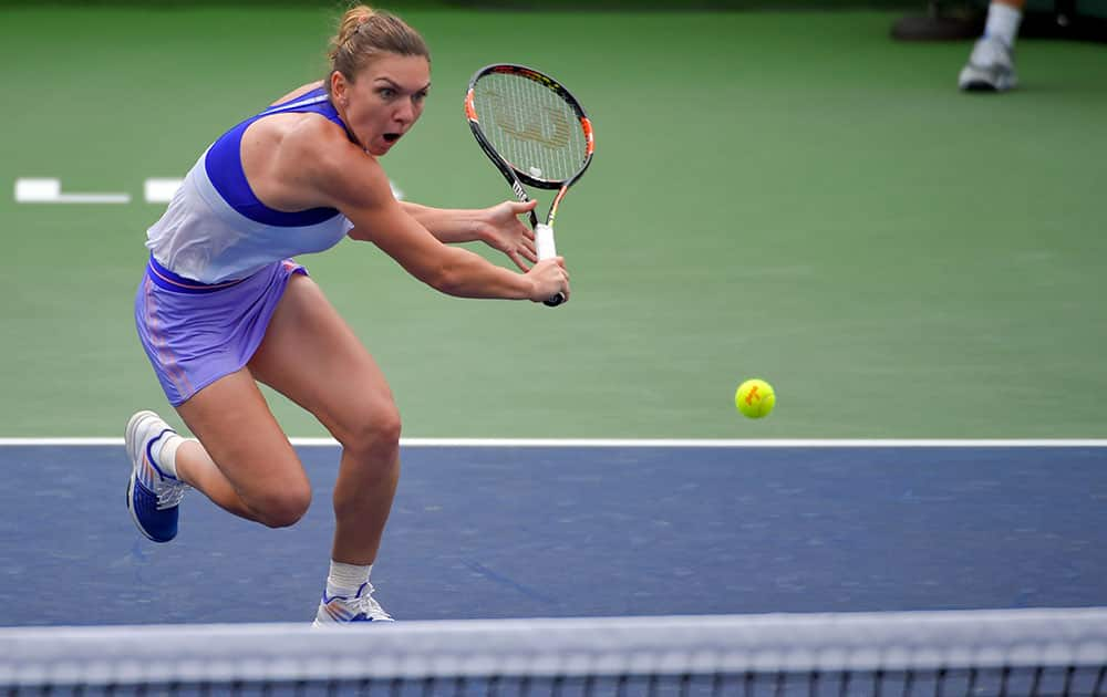 Simona Halep, of Romania, returns to Carla Suarez Navarro, of Spain, during their match at the BNP Paribas Open tennis tournament.