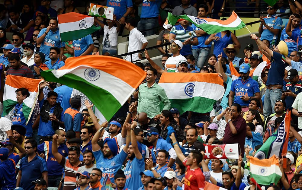 Indian fans wave their flags as they cheer their team during their Cricket World Cup quarterfinal match against Bangladesh in Melbourne, Australia.