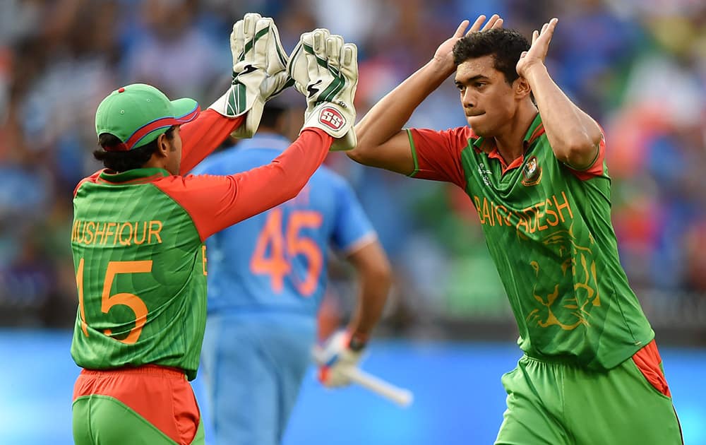 Bangladesh’s Taskin Ahmed celebrates with teammate Mushfiqur Rahim, left, after dismissing India's Rohit Sharma during their Cricket World Cup quarterfinal match in Melbourne.