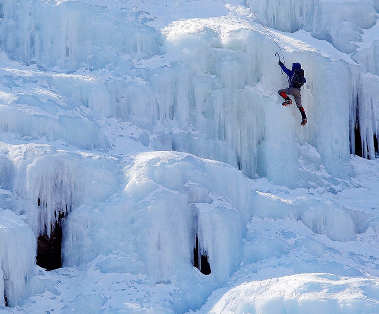 An ice climber makes their way up Frankenstein Cliff as freezing temperatures remain on the last full day of winter, in Harts Location.