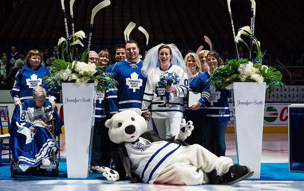 Jennifer Rogers and Scott Protomanni, pose for a photo with family and Carlton the Bear after getting married at the Toronto Maple Leafs Blue & White Wedding, the first wedding ever at the Air Canada Centre in Toronto.