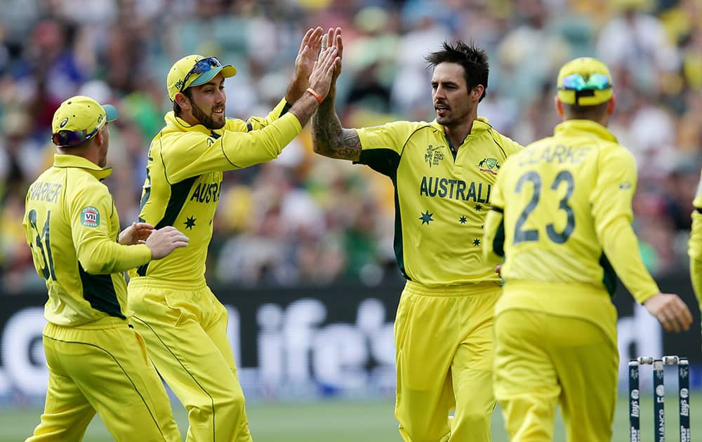 Australia's Mitchell Johnson, is congratulated by teammates after taking the wicket of Pakistan's Haris Sohail during their Cricket World Cup quarterfinal match in Adelaide.