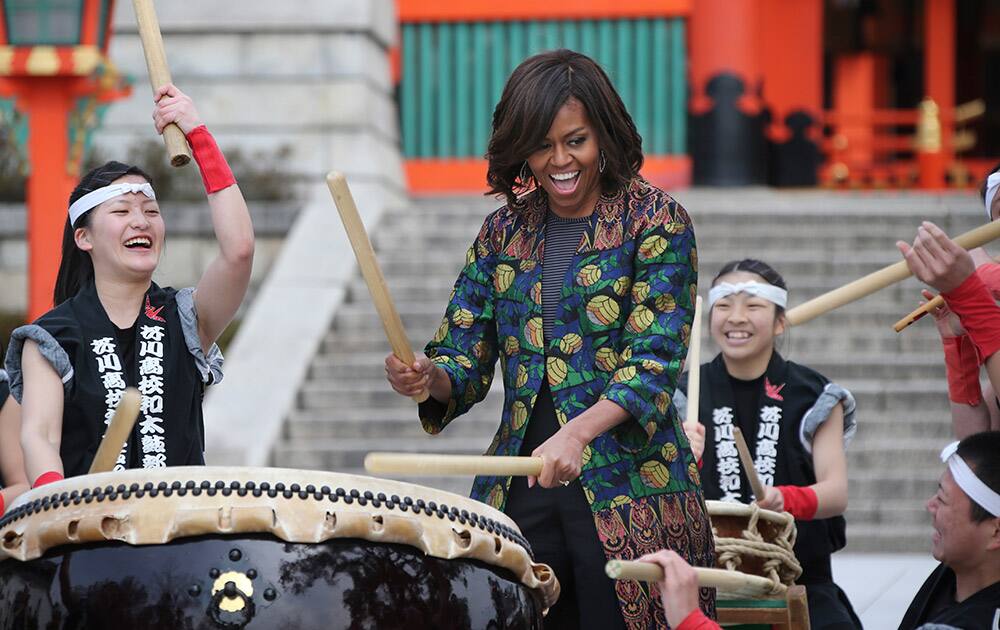 US first lady Michelle Obama performs Taiko with the Akutagawa High School Taiko Club during her visit to Fushimi Inari Shinto Shrine in Kyoto, in western Japan.