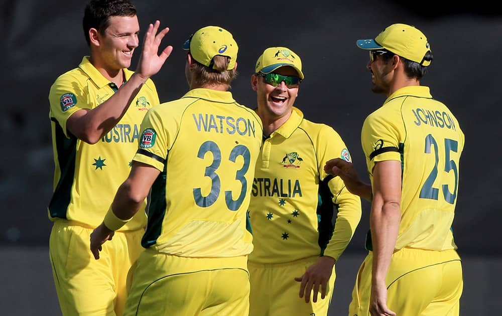 Australia's Josh Hazlewood is congratulated by teammates after taking the wicket of Pakistan's Sohaib Maqsood during their Cricket World Cup quarterfinal match in Adelaide, Australia.