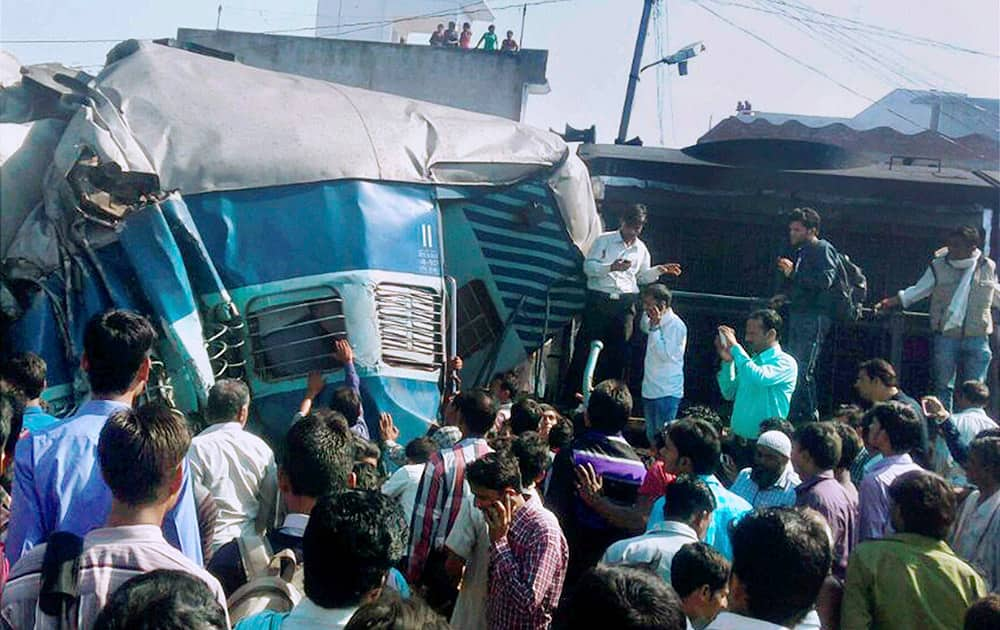 People gather at the accident site after the Dehradun-Varanasi Janata Express derailed at the Bachhrawan railway station in Raebareli.