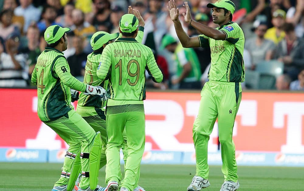 Pakistan's Wahab Riaz is congratulated by his teammates after taking the wicket of Australia's David Warner during their Cricket World Cup quarterfinal match in Adelaide, Australia.