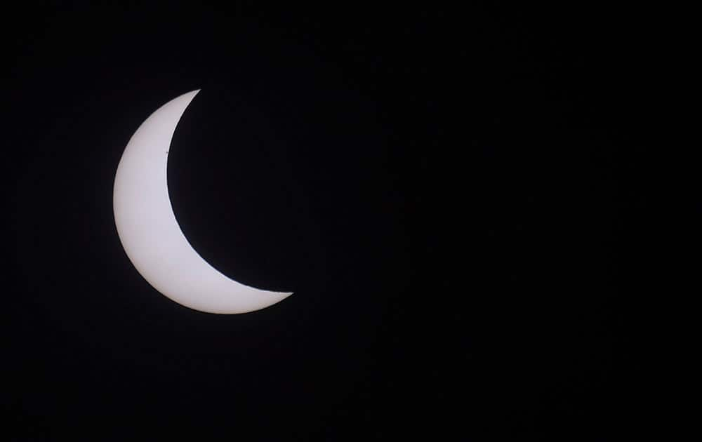 The moon blocks part of the sun during a solar eclipse seen in Northumberland, England.