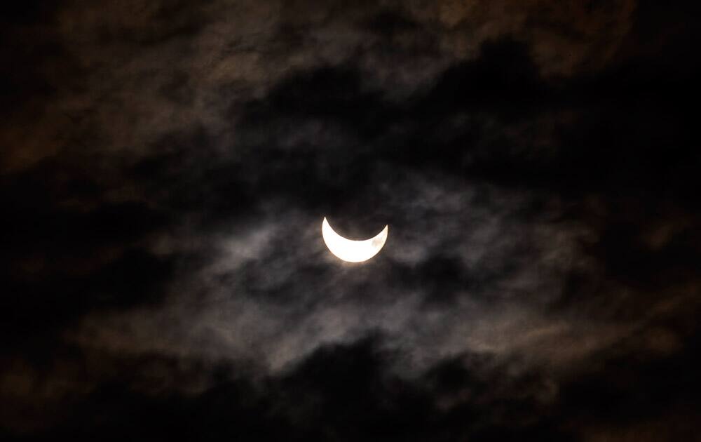 The moon blocks part of the sun during a solar eclipse seen in Barcelona, Spain.