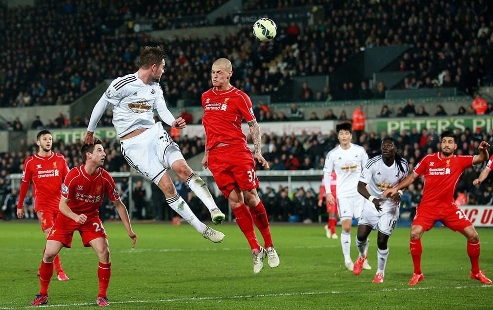 Swansea City's Gylfi Sigurdsson has a header at goal against Liverpool during their English Premier League soccer match at the Liberty Stadium, in Swansea, England.