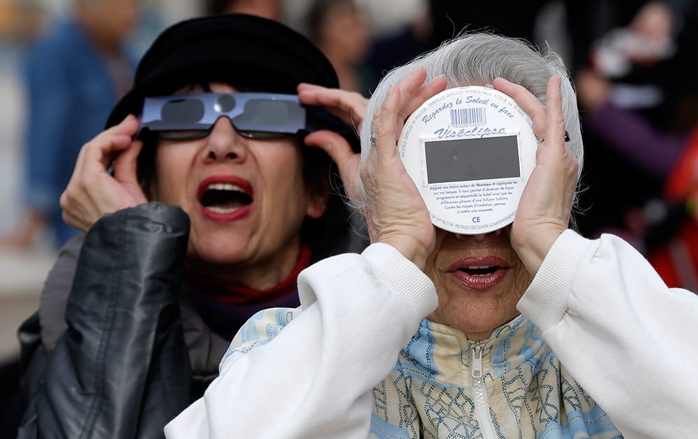 People look at a solar eclipse in the sky of Nice, southeastern France.