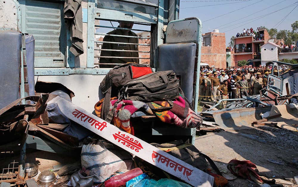 A police officer looks at the wreckage of a train compartment at the site of an accident near Bachhrawan village in Uttar Pradesh.