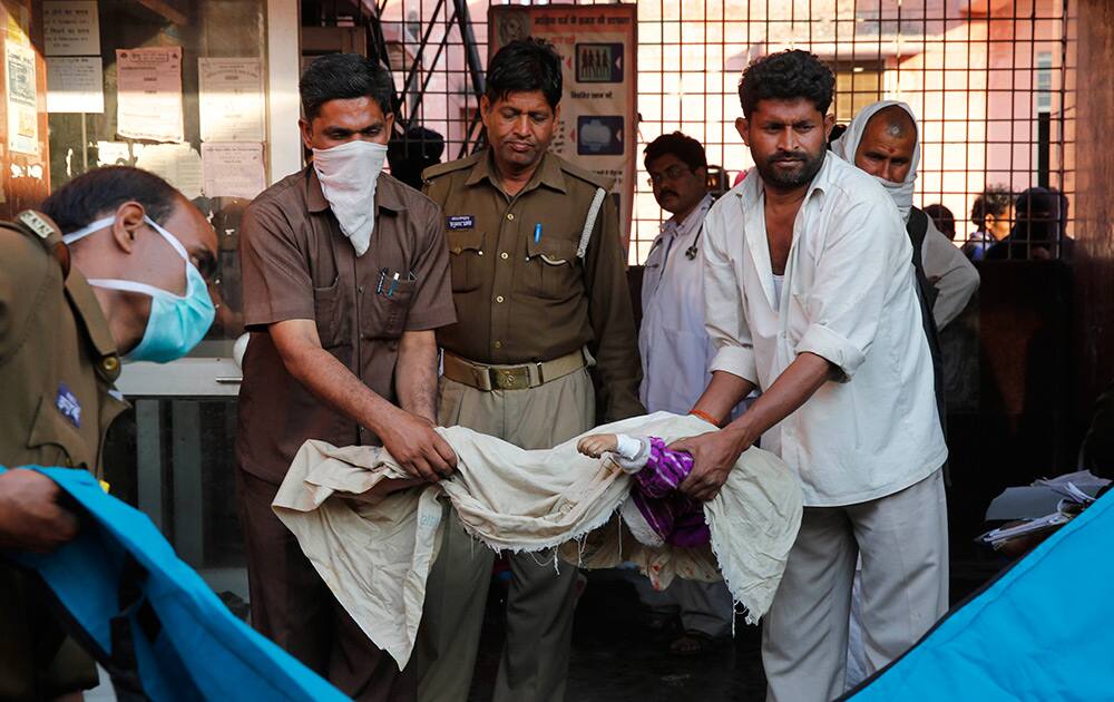 Relatives carry the body of a young victim of a train accident, at a hospital in Bachhrawan village, in Uttar Pradesh.