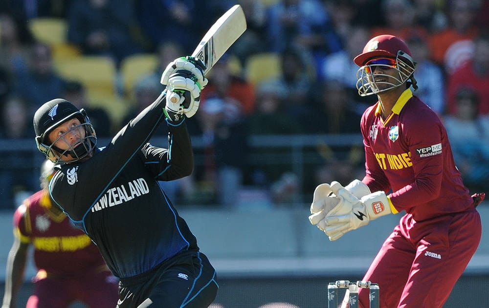 New Zealand’s Martin Guptill hits the ball for six runs as West Indies wicketkeeper Denesh Ramdin watches during their Cricket World Cup quarterfinal match in Wellington, New Zealand.