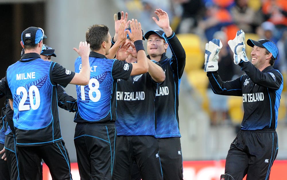 New Zealand’s Trent Boult, is congratulated by teammates after the dismissal of West Indies Denesh Ramdin during their Cricket World Cup quarterfinal match in Wellington.