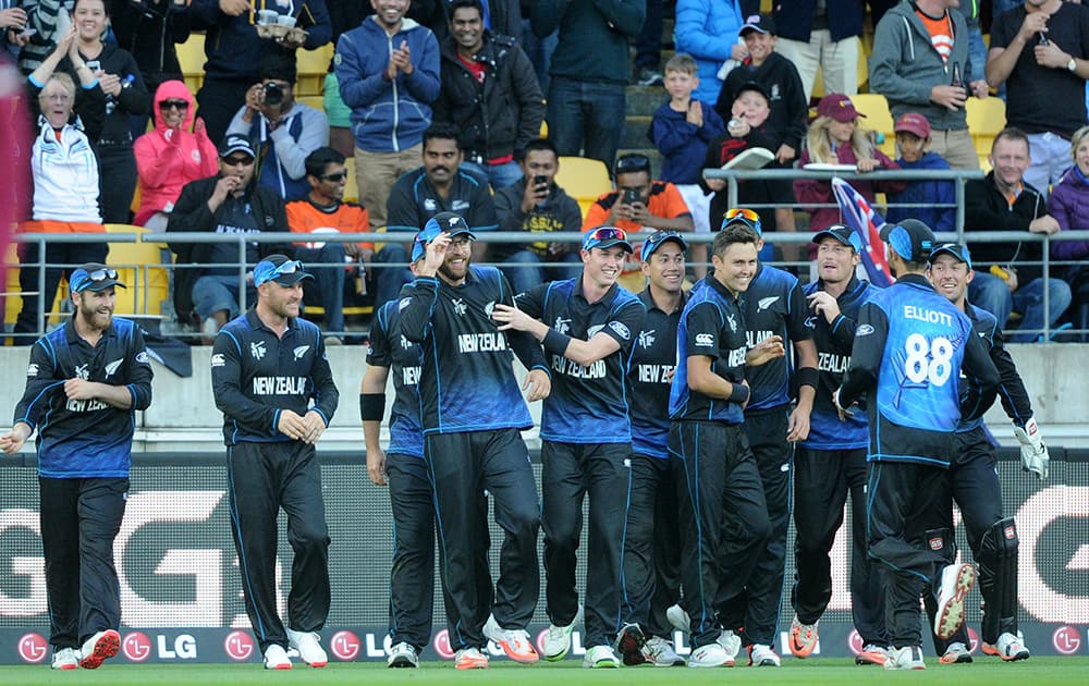 New Zealand’s Dan Vettori, is congratulated by his teammates after taking a catch to dismiss West Indies Marlon Samuels during their Cricket World Cup quarterfinal match in Wellington.