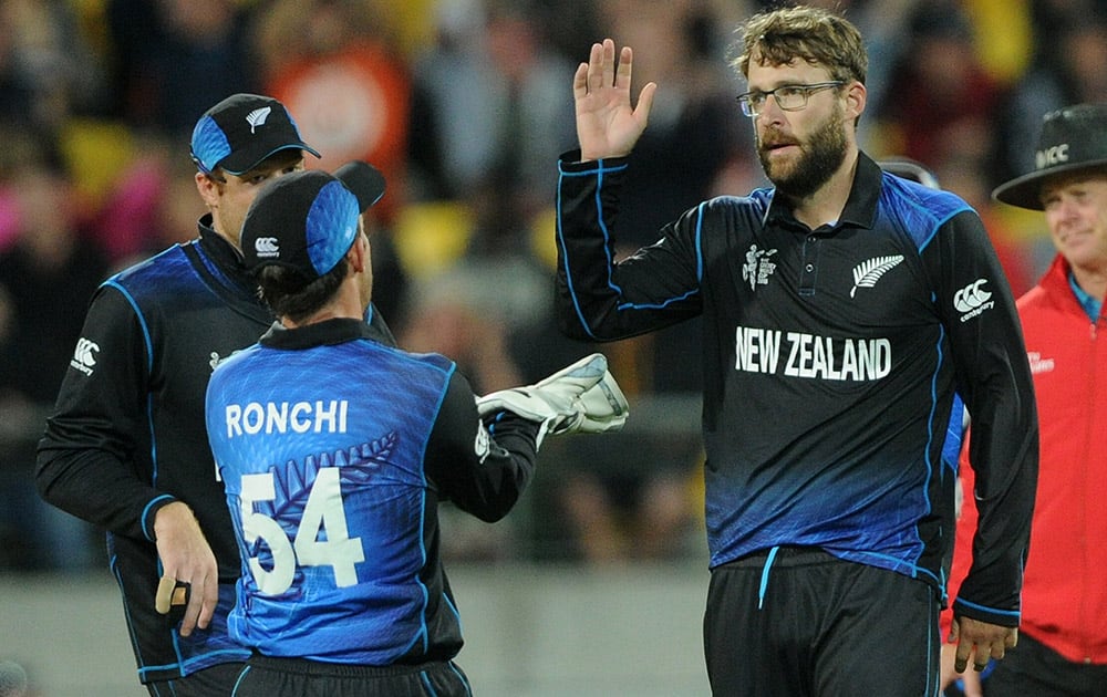 New Zealand’s Dan Vettori, right, is congratulated by teammate Luke Ronchi after bowling out West Indies batsman Jonathan Carter during their Cricket World Cup quarterfinal match in Wellington, New Zealand.