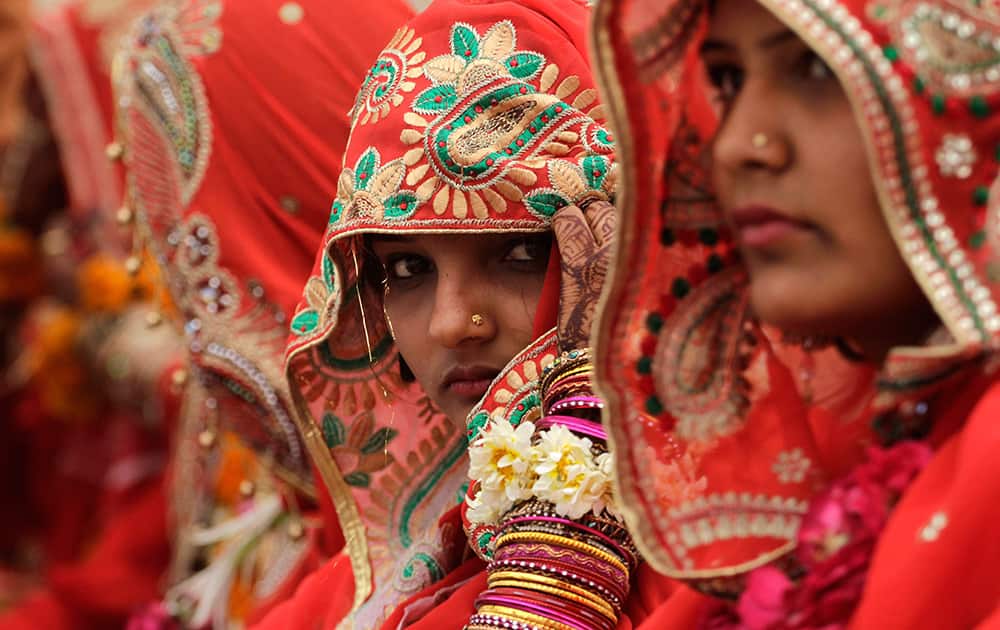 A bride adjusts her veil during a mass marriage ceremony in Ahmadabad.