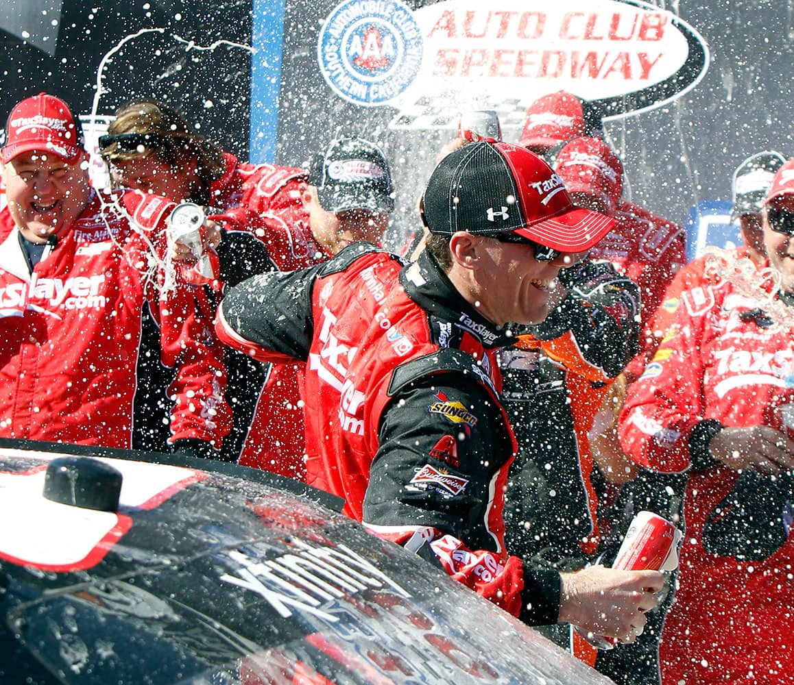 Kevin Harvick gets drenched by his team after winning the NASCAR Xfinity Sprint Cup Series auto race in Fontana, Calif.