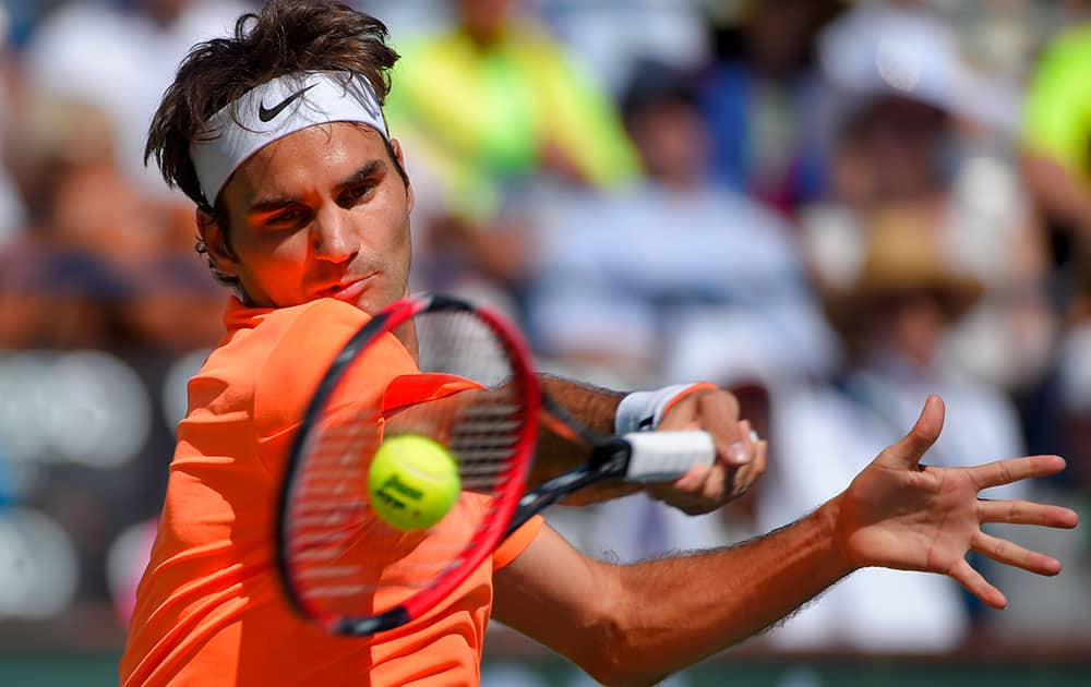 Roger Federer, of Switzerland, returns to Milos Raonic, of Canada, during their semifinal match at the BNP Paribas Open tennis tournament.