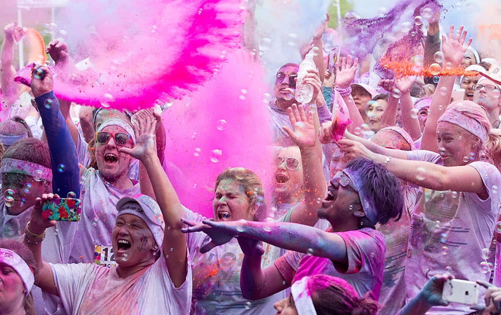 Participants of Color Up 5K are doused with powdered color during a post-run party following the third-annual run at Lions Park in Temple, Texas.