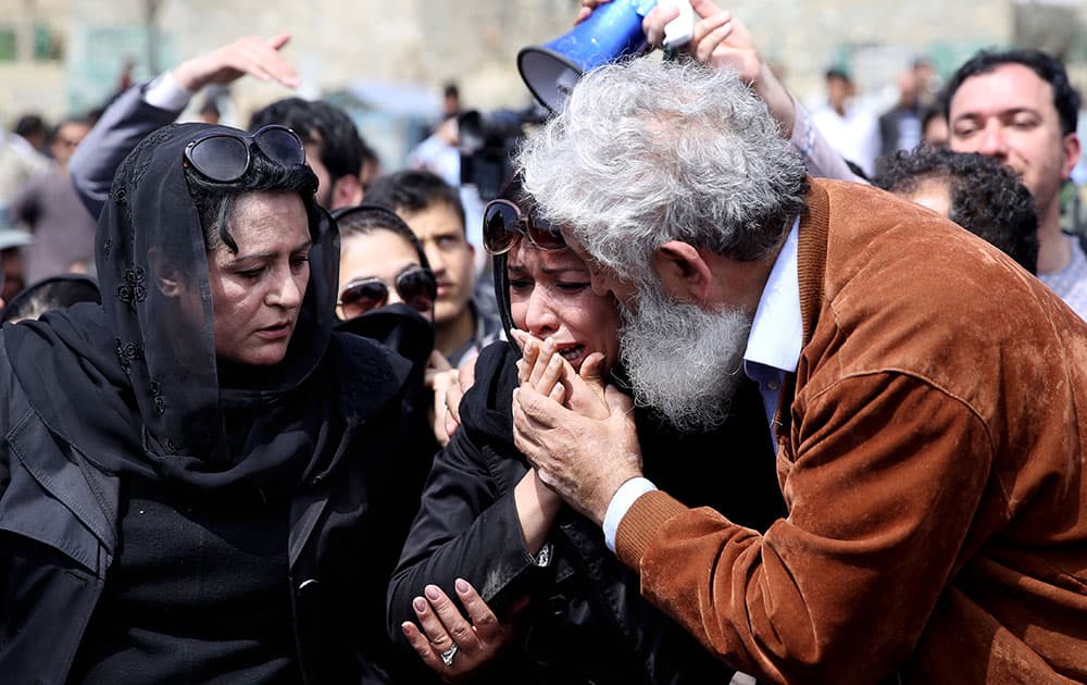 An Afghan civil society activist is comforted by a man as she mourns during the funeral of 27-year-old Farkhunda, an Afghan woman who was beaten to death by a mob, in Kabul, Afghanistan.